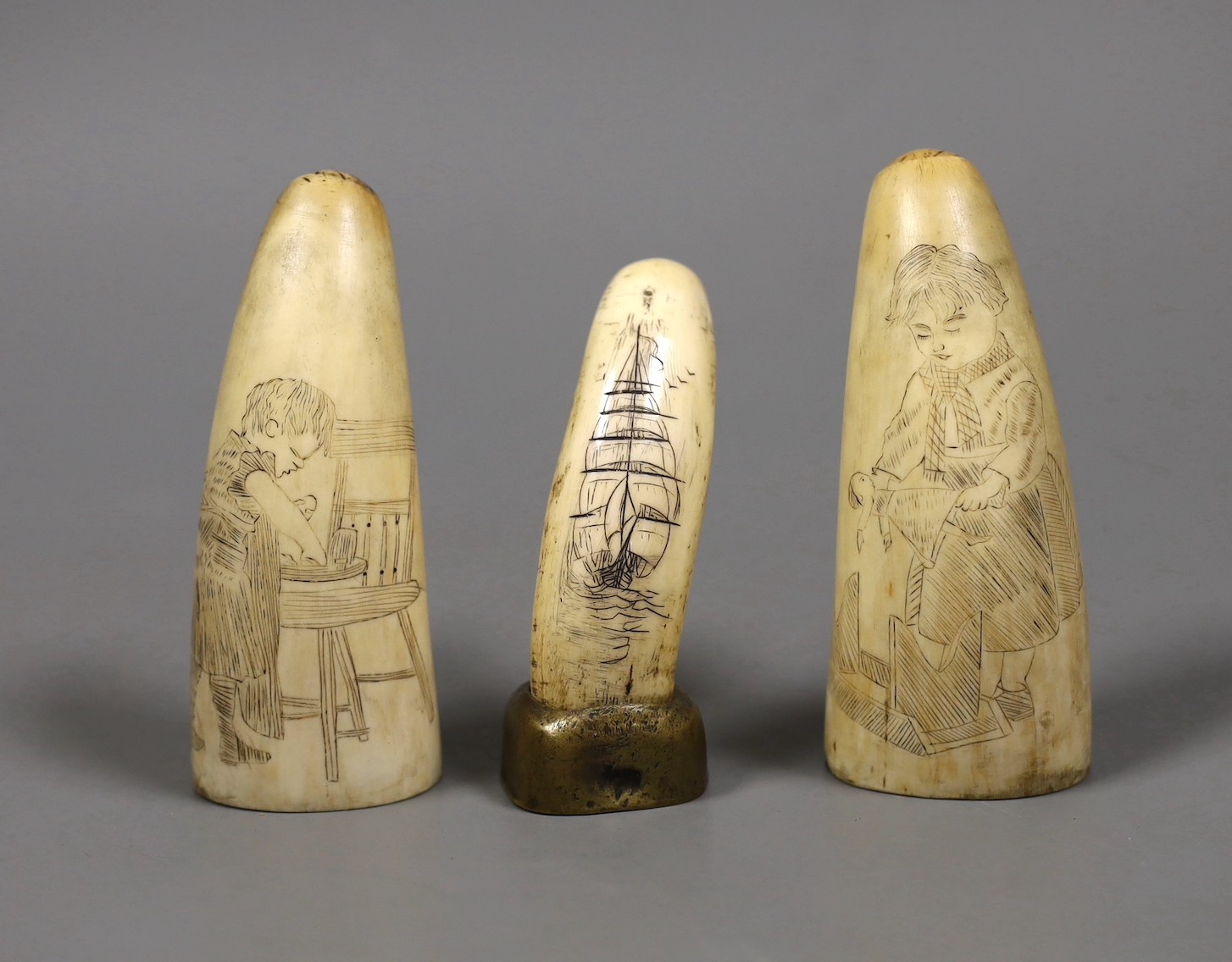 Three 19th century scrimshaw sperm whale teeth, tallest 10cm